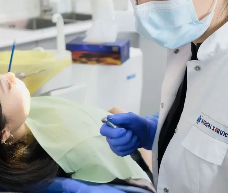 Balçova'da bir hastaya kompozit diş dolgusu uygulayan diş hekimi